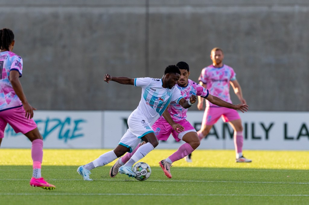 Andre Lewis dribbles past a Forward Madison defender