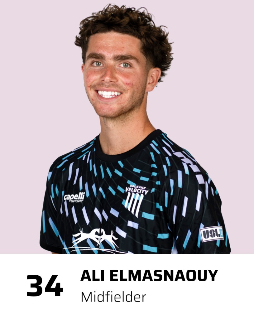 A portrait of a young man smiling, wearing a black athletic jersey with colorful patterns, labeled as Ali Elmasnaouy, midfielder, number 34, for Spokane Velocity.