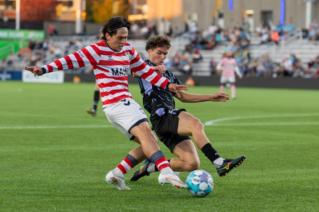 Ali Almasnaouy battles a Portland Hearts of Pine Defender for a soccer ball