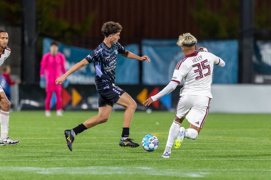 Ali Elmasnaouy dribbles, being chased by a Chattanooga Red Wolves player